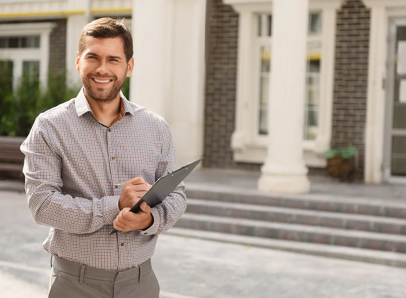 smiling property investor with a clipboard